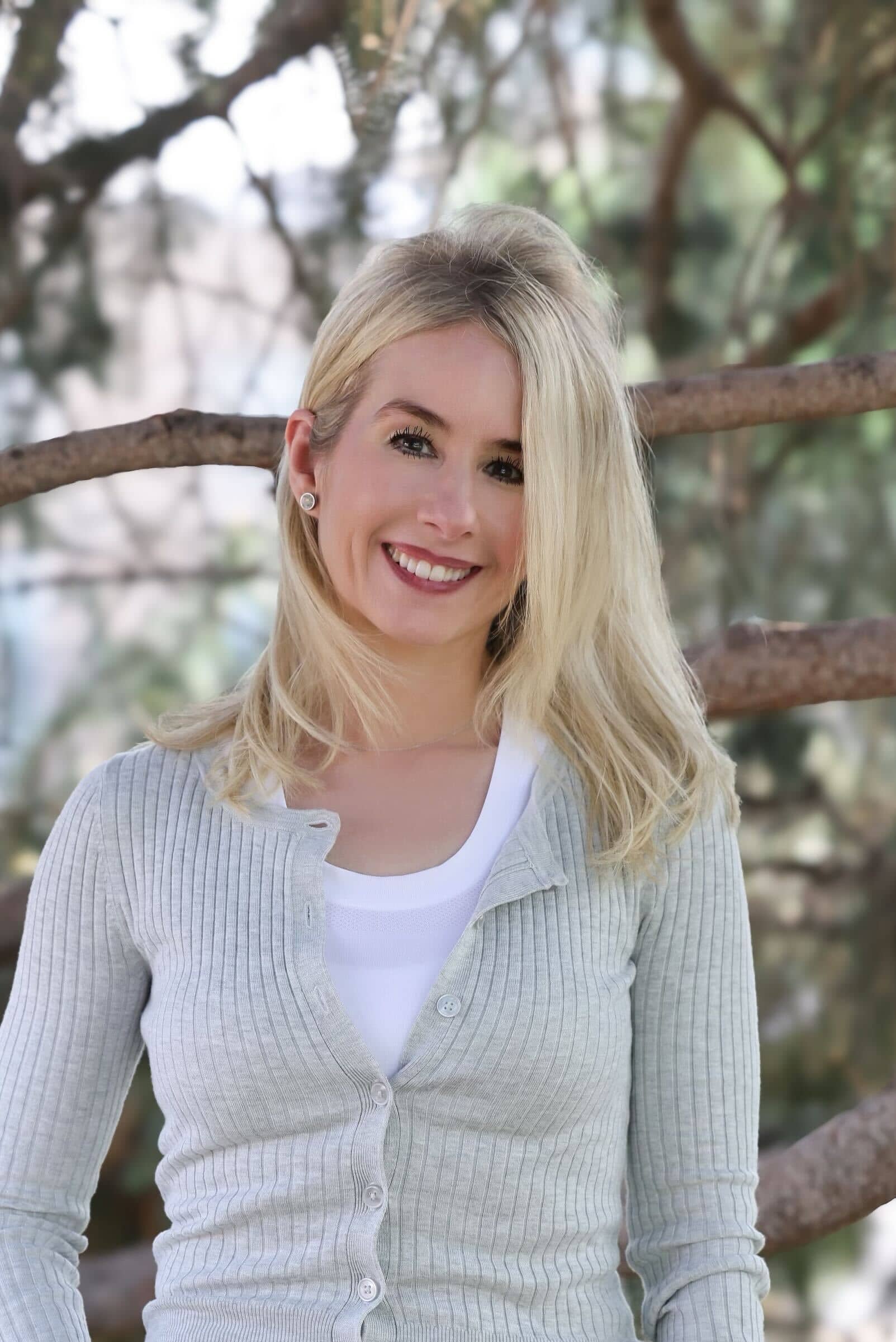 Sheree standing by a tree, smiling