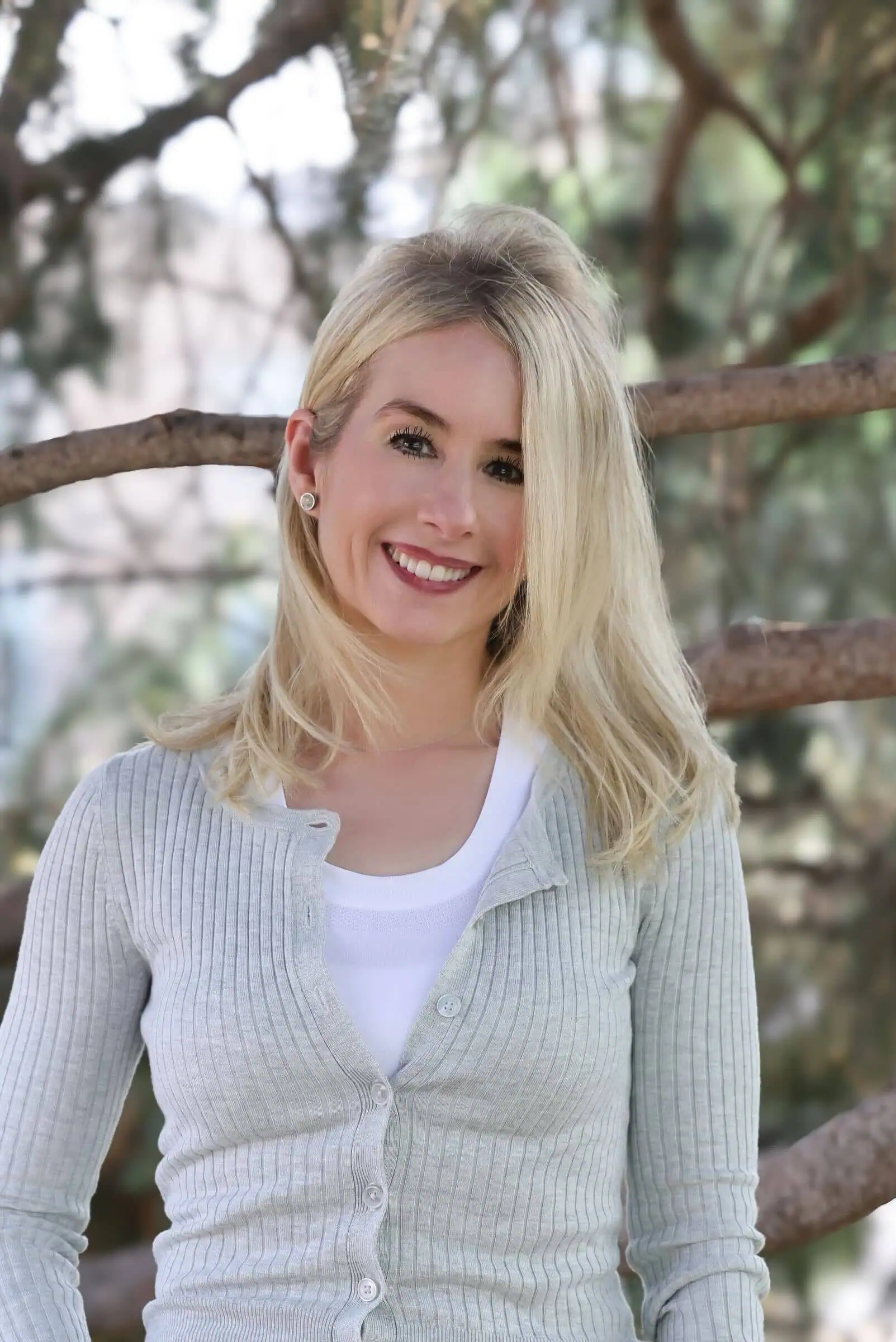 Sheree standing by a tree, smiling
