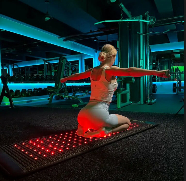Woman sitting on a PEMF Mat
