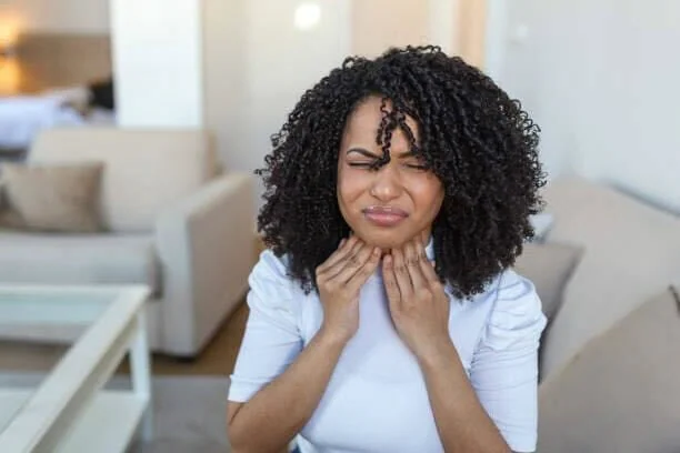 Woman touching her neck.