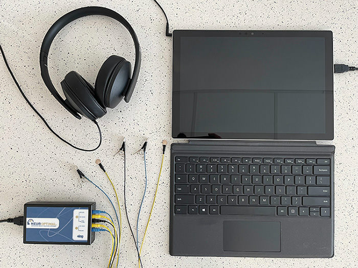 A laptop with cords for a neurofeedback scan.